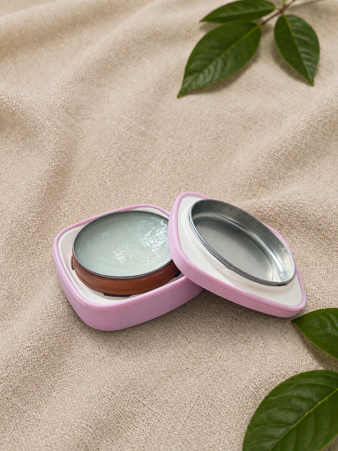 Caseline pink case fully open showing the tin inside the pink case on a neutral background